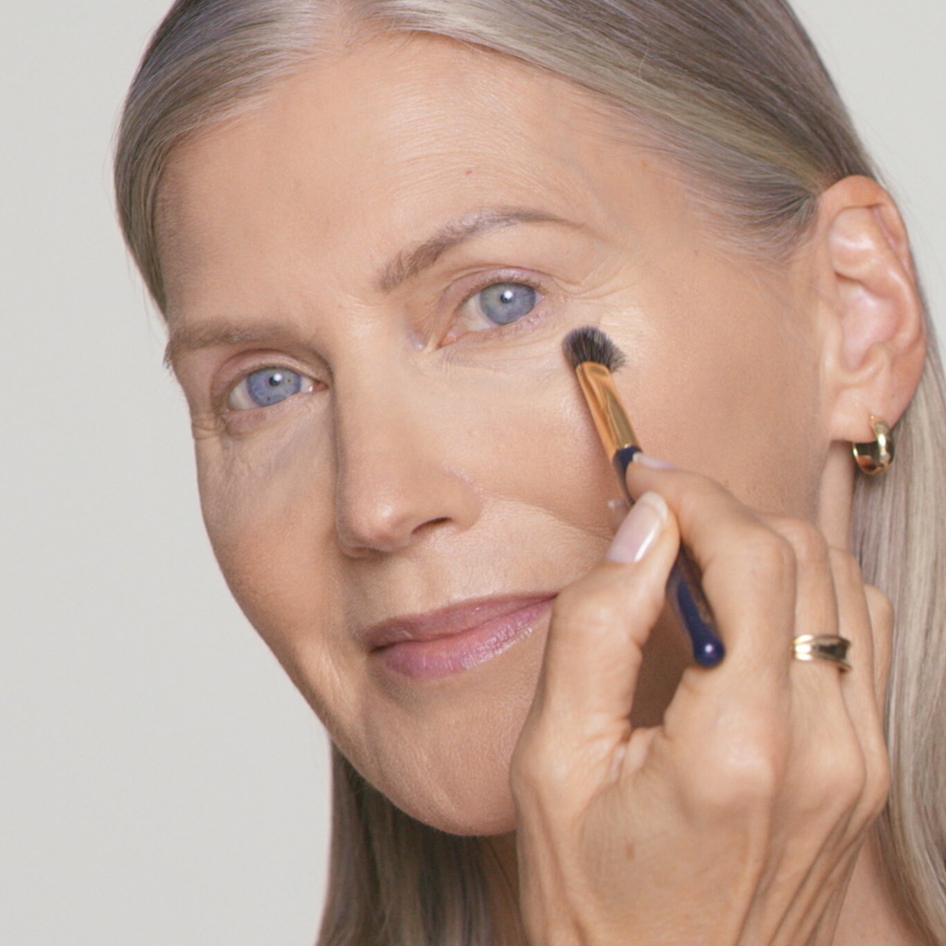 Model applies gel-creme under eyes